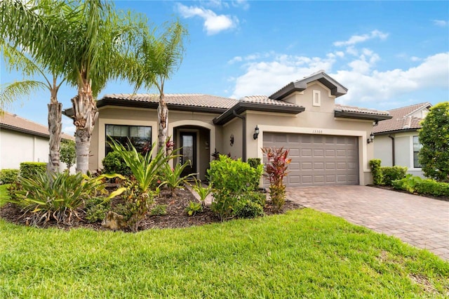 mediterranean / spanish-style home featuring a garage and a front lawn