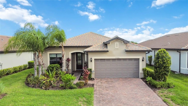 mediterranean / spanish-style home with a garage and a front lawn