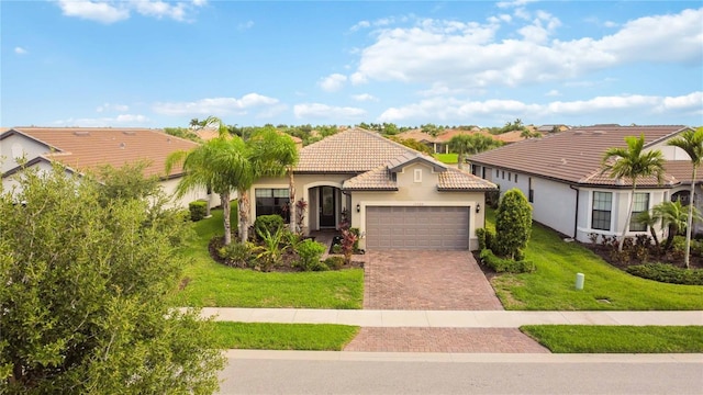 mediterranean / spanish home featuring a garage and a front yard