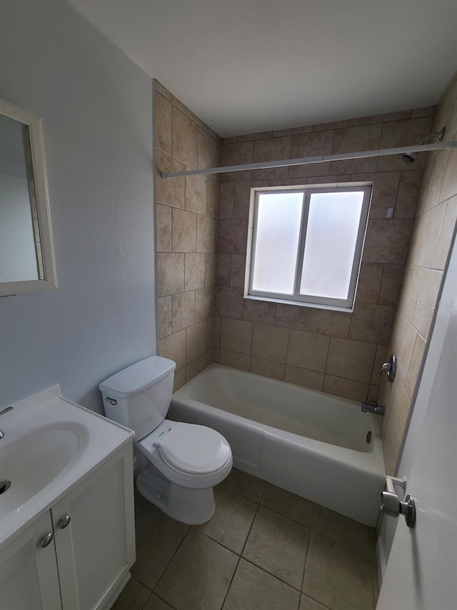 full bathroom featuring vanity, tile patterned flooring, toilet, and tiled shower / bath