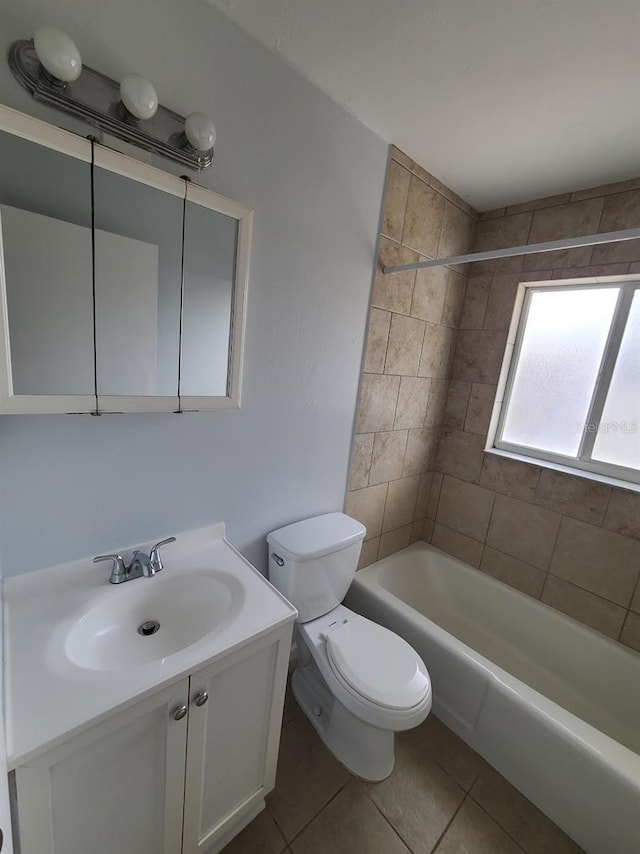 full bathroom with tile patterned flooring, vanity, tiled shower / bath combo, and toilet