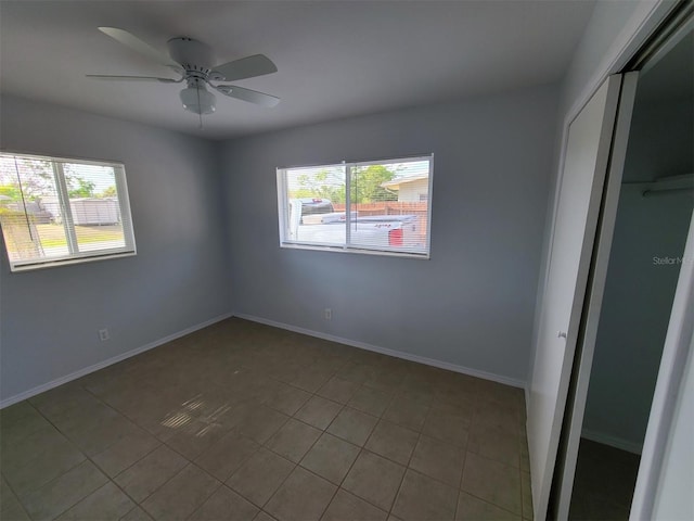 spare room featuring light tile patterned floors and ceiling fan