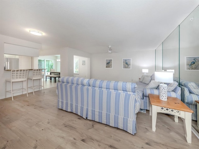 living room featuring ceiling fan and light hardwood / wood-style floors