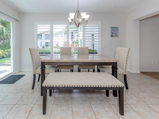 dining space featuring baseboards, an inviting chandelier, and light tile patterned flooring