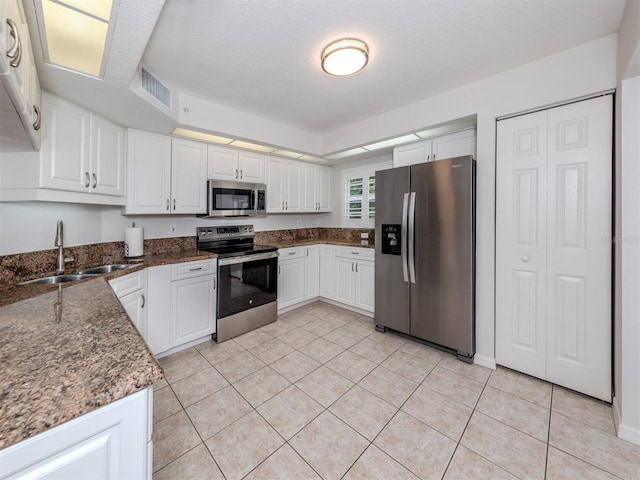 kitchen with appliances with stainless steel finishes, white cabinetry, and sink