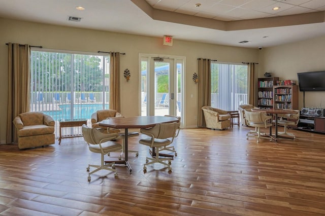 dining area featuring wood-type flooring and a paneled ceiling