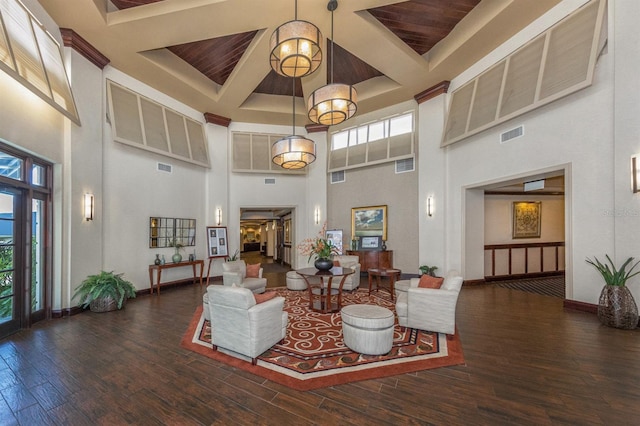 living room with dark wood-type flooring, a chandelier, and a towering ceiling