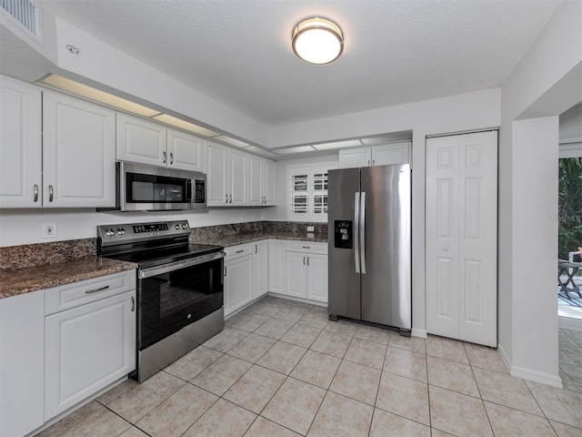 kitchen featuring white cabinetry, light tile patterned flooring, visible vents, and appliances with stainless steel finishes