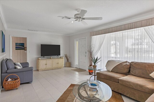 tiled living room with ornamental molding and ceiling fan