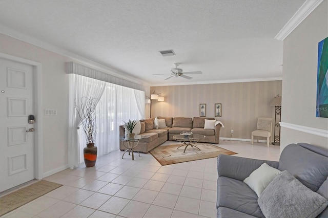 tiled living room featuring ceiling fan, a textured ceiling, and ornamental molding