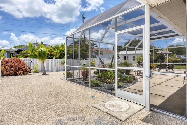 exterior space featuring glass enclosure and a patio