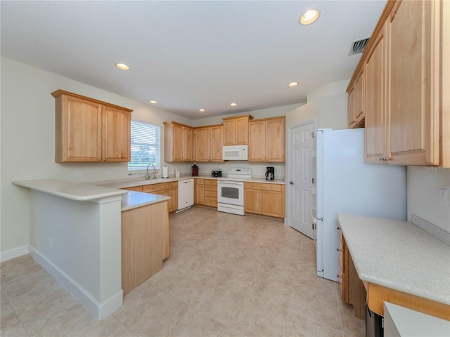 kitchen with light brown cabinets, sink, and white appliances