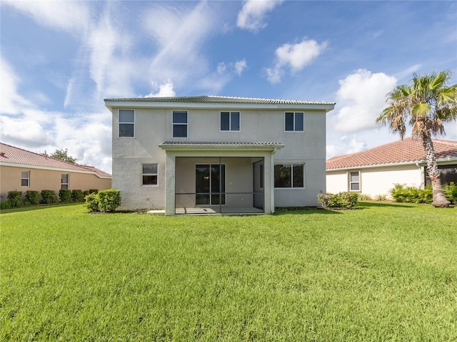 back of property featuring a sunroom and a yard