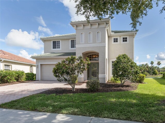 mediterranean / spanish-style home featuring a front yard and a garage