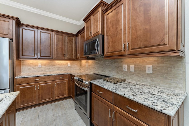 kitchen featuring decorative backsplash, stainless steel appliances, light stone counters, and ornamental molding