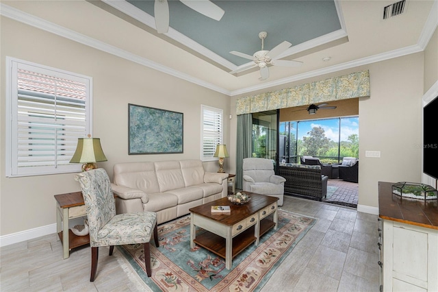 living room featuring a tray ceiling and crown molding