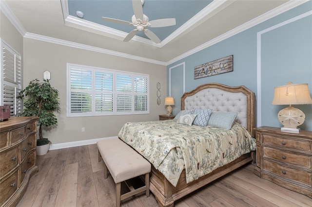 bedroom featuring a tray ceiling, ceiling fan, hardwood / wood-style flooring, and ornamental molding