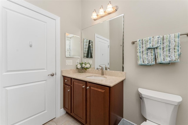 bathroom featuring tile patterned flooring, vanity, and toilet