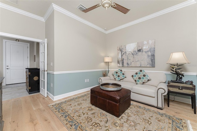 living room with hardwood / wood-style floors, ceiling fan, and ornamental molding