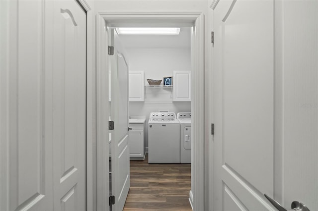 clothes washing area with cabinet space, dark wood-type flooring, and independent washer and dryer