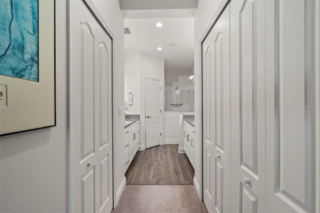 hall with visible vents, recessed lighting, and dark wood-style flooring