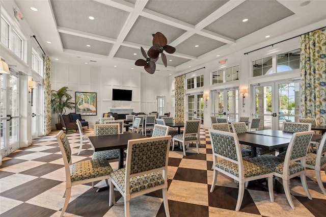 dining room featuring coffered ceiling, french doors, and a towering ceiling