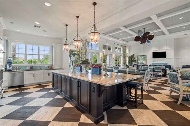 kitchen with stainless steel dishwasher, coffered ceiling, white cabinetry, a kitchen island, and hanging light fixtures