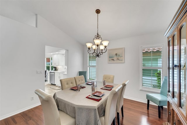 dining room with wood-type flooring, lofted ceiling, and an inviting chandelier