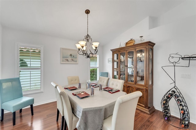 dining space with a chandelier, dark hardwood / wood-style flooring, and vaulted ceiling