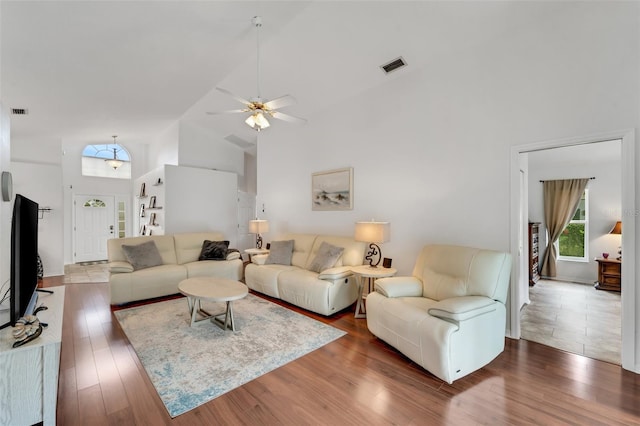 living room with dark hardwood / wood-style floors, high vaulted ceiling, and ceiling fan