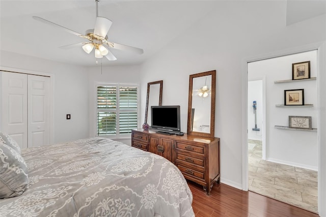 bedroom with ceiling fan, a closet, and dark wood-type flooring