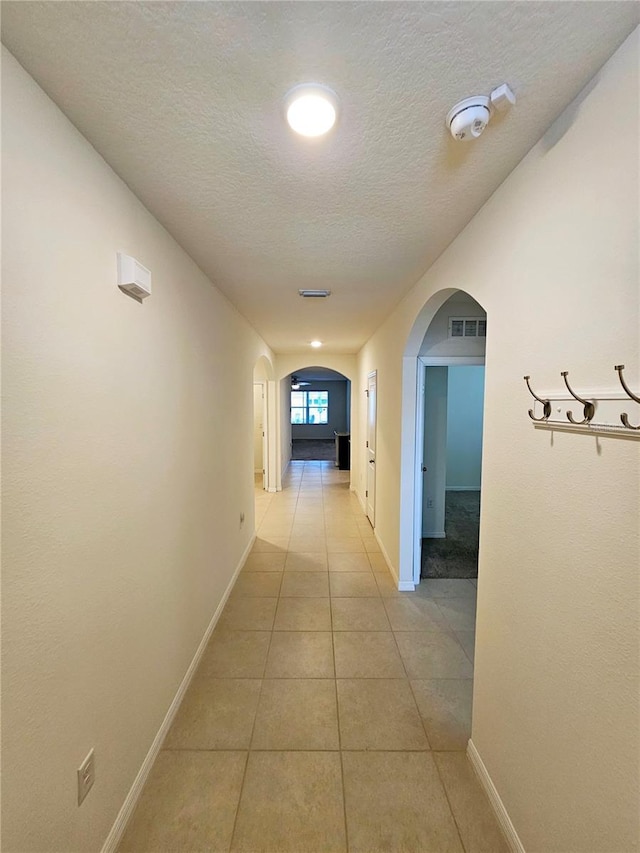 hall featuring light tile patterned floors