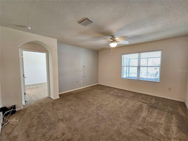 carpeted spare room featuring a textured ceiling and ceiling fan