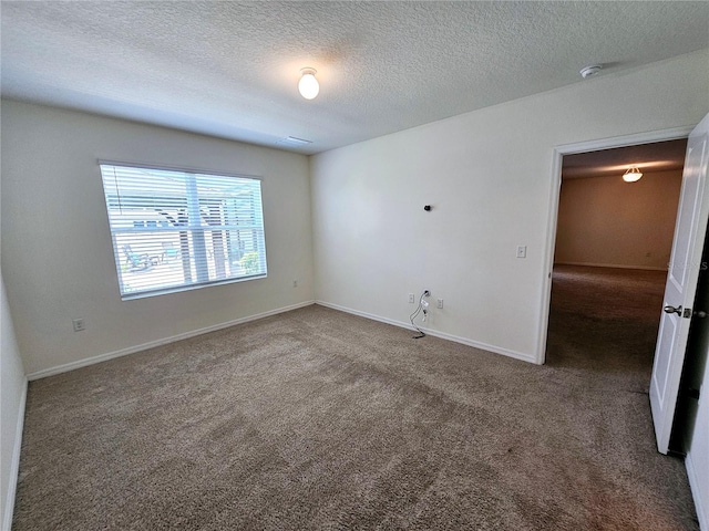 carpeted empty room with a textured ceiling