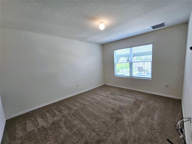 empty room featuring dark colored carpet and a textured ceiling