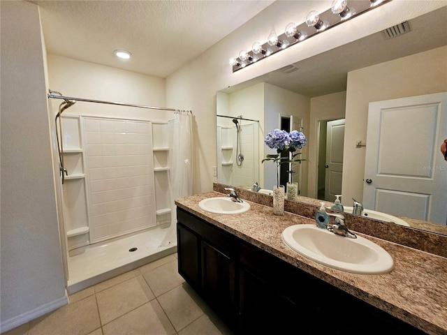 bathroom with tile patterned floors, a shower with curtain, a textured ceiling, and vanity