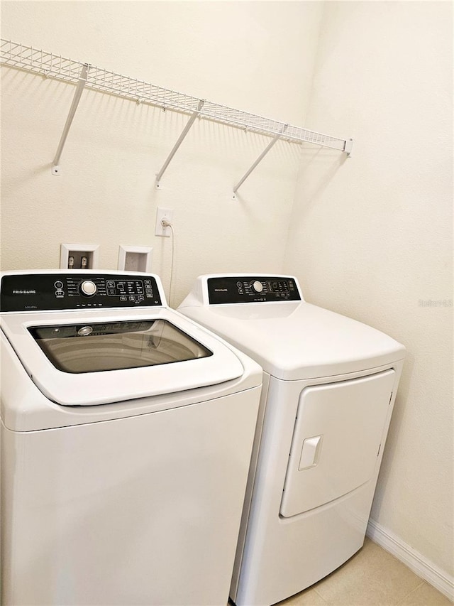 laundry area featuring light tile patterned floors and washer and clothes dryer