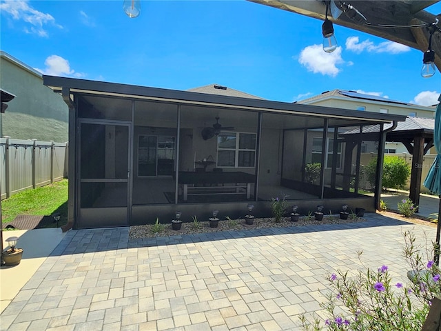 rear view of property featuring a sunroom and a patio