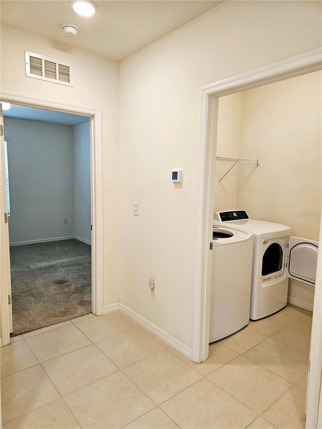 laundry room featuring independent washer and dryer and light tile patterned floors