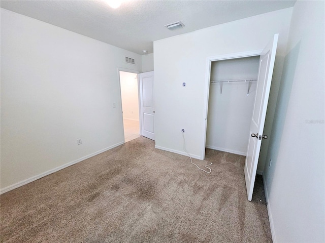 unfurnished bedroom with a closet and carpet floors