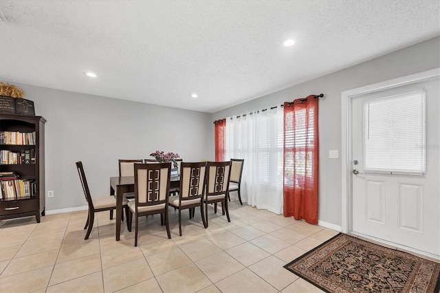 tiled dining room with a textured ceiling