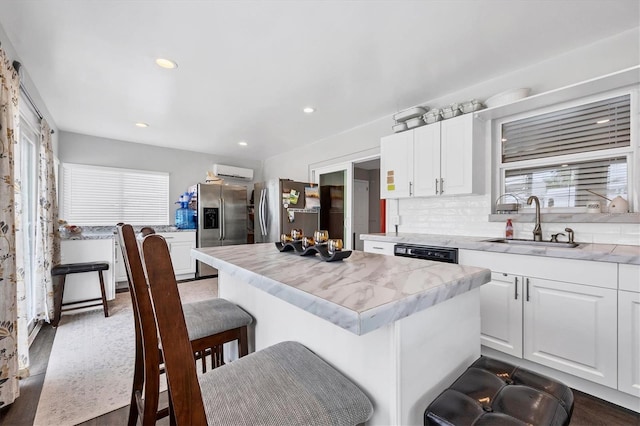 kitchen featuring sink, white cabinets, a wealth of natural light, and stainless steel fridge