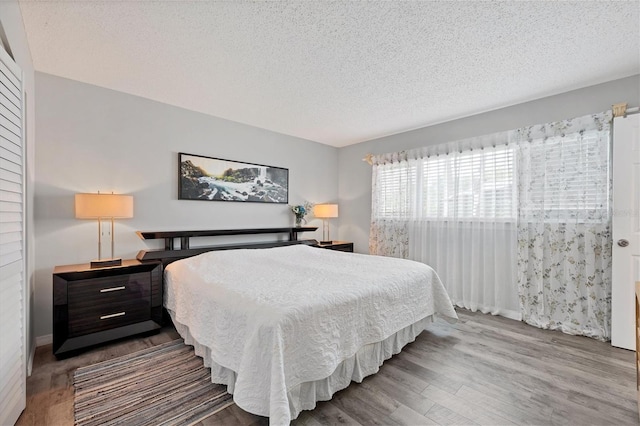 bedroom featuring hardwood / wood-style flooring and a textured ceiling