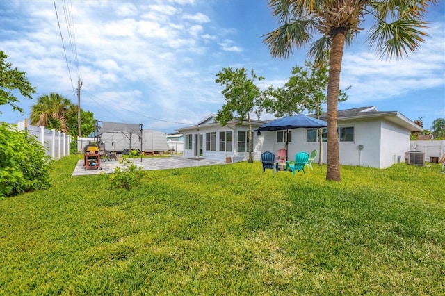 rear view of house with a patio area, a yard, and central air condition unit