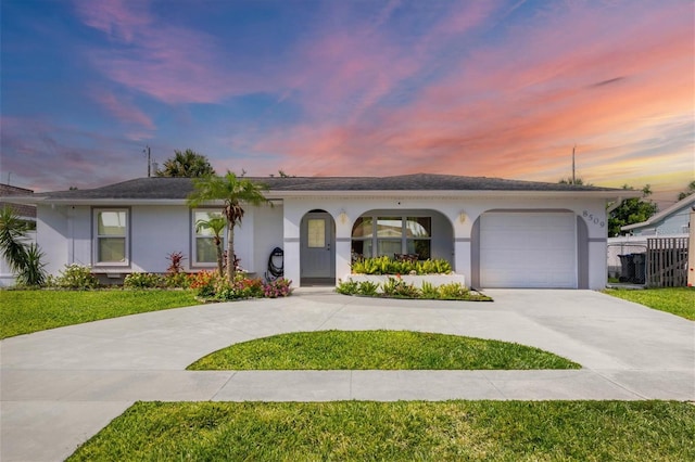 ranch-style house featuring a garage and a yard