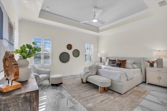 bedroom featuring a raised ceiling, multiple windows, and ceiling fan