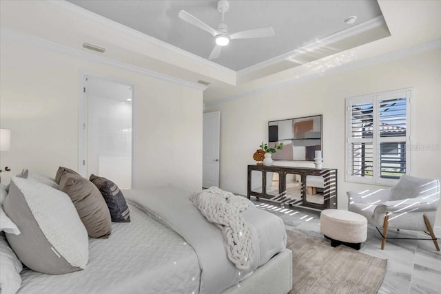 bedroom featuring ceiling fan, a raised ceiling, crown molding, and connected bathroom