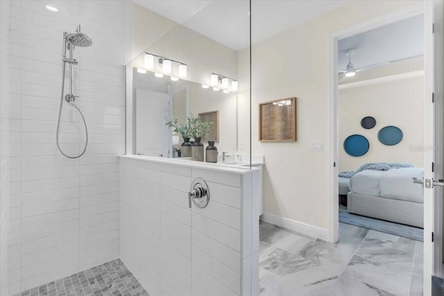 bathroom with a tile shower, vanity, and ceiling fan