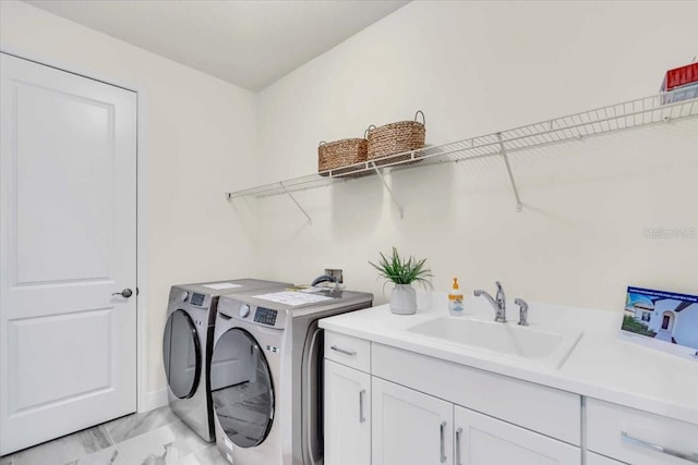 washroom featuring washer and dryer, cabinets, and sink