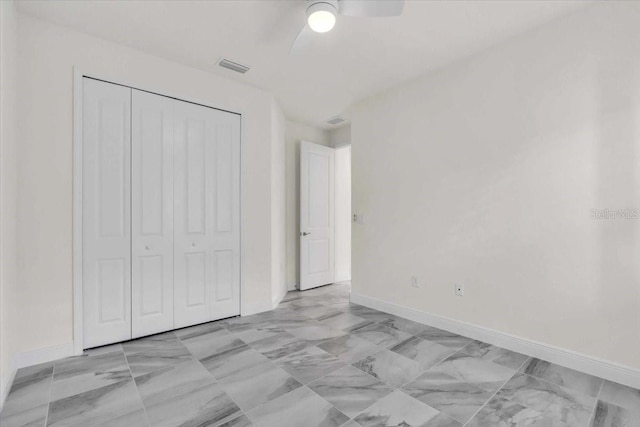 unfurnished bedroom with ceiling fan and a closet